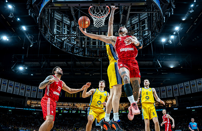 Trener drużyny Alba Berlin rozmawiąjący z zawodnikami.