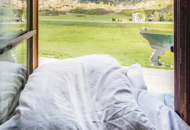 Foto: in einem geöffneten Fensterrahmen liegt Bettzeug.