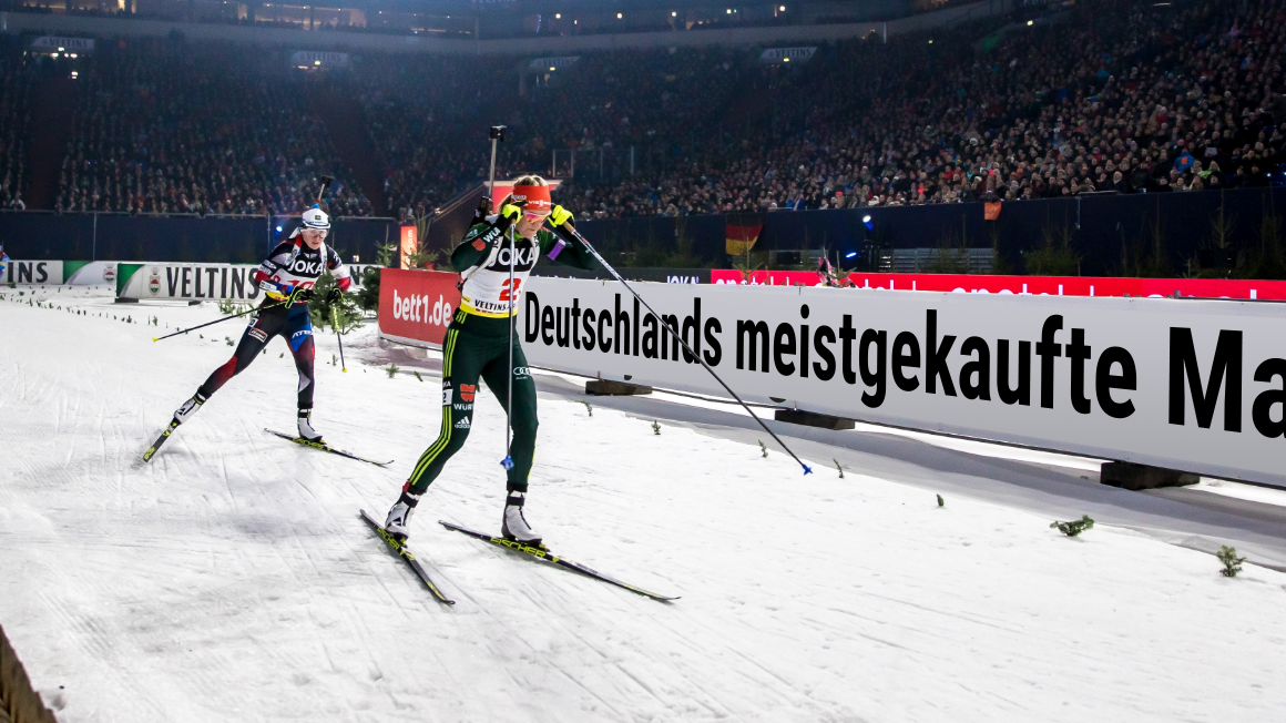 Sportowcy ścigający się na nartach podczas biathlonu.