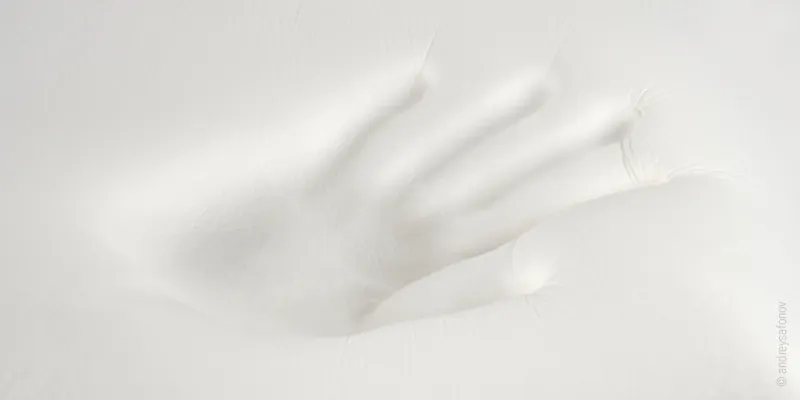 Fragment toppera z pianki memory z odciśniętą dłonią.