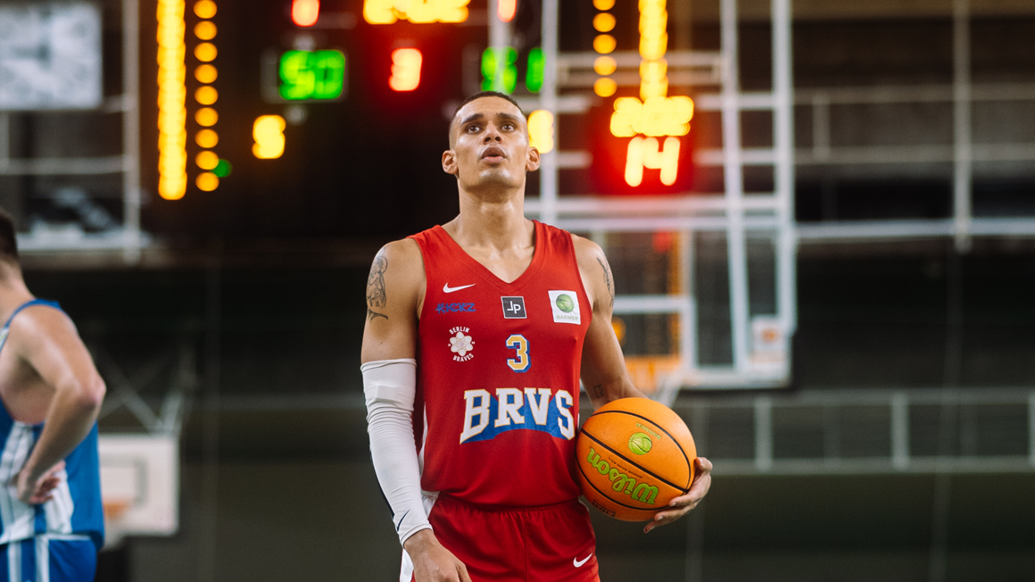 Członek drużyny Berlin Braves z piłką do koszykówki w ręce.