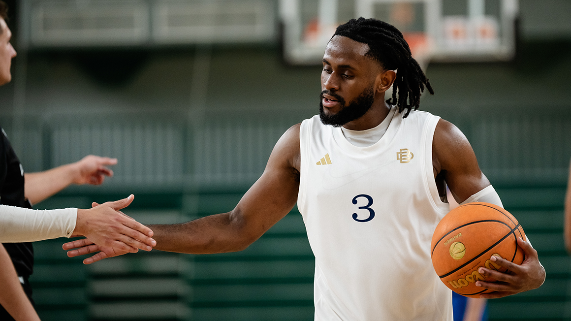 Członek drużyny Berlin Dreams z piłką do koszykówki w ręce przybija piątkę fanom.