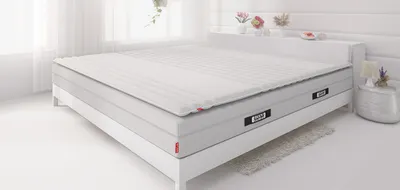Materac BODYGUARD® z topperem na białym łóżku